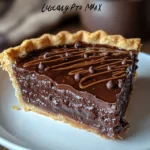 Slice of hot fudge pie topped with vanilla ice cream on a white plate